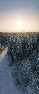 photo from a flying drone, a small planet and a winter landscape, pines and spruces are covered with snow