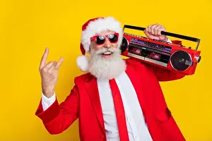 Claus Prints: Photo of funny charming claus wear red tux costume tux showing hard rock gesture listening boom box isolated yellow