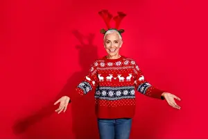 Antlers Prints: Photo of lovely pensioner lady stretch hands welcome deer horns wear print sweater celebrating new year isolated red