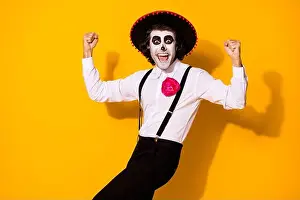 Muertos Prints: Photo portrait of cheerful crazy nice handsome funny mexican guy in traditional costume raising fists up isolated
