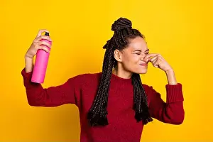 Smell Prints: Photo of spoiled shocked dark skin woman dressed red sweater arm close nose disgusted spray aroma isolated yellow color