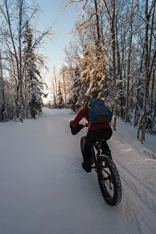 Pedaling Prints: Photo of woman snow biking at sunset
