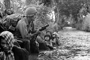 Mother Prints: Photograph of two South Vietnamese children gazing at an American paratrooper holding an M79 grenade launcher as they