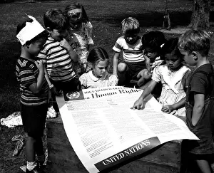 Universal Prints: Photograph taken of children of the United Nations International Nursery School looking at a poster of the Universal