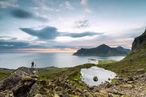 Norwegian Prints: Photographer admires clouds of midnight sun on the cold sea Flakstad Moskenesøya Nordland county Lofoten Islands Norway