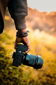 Videography Prints: Photographer is holding a camera, DSLR camera with blur background selective focus image