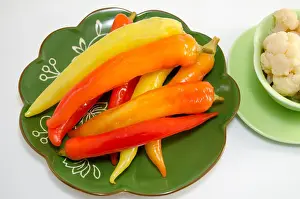 Chili Peppers Prints: Pickled peppers on a green plate isolated on white