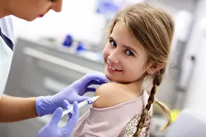 Pediatrician Prints: Picture of brave little girl receiving injection or vaccine with a smile