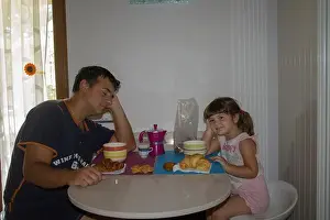 Blueberry Prints: Picture of a sleepy and just waking up dad with his daughter while having breakfast in the morning