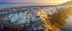 Santorini Prints: Picturesque Aerial drone view of famous Oia village with white houses during sunrise on Santorini island