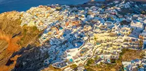 Santorini Prints: Picturesque Aerial drone view of famous Oia village with white houses during sunrise on Santorini island