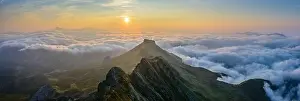 Castile Prints: Picturesque aerial view of green mountain range and thick clouds located against morning sky with bright sunrise sun