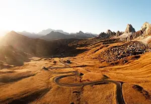 Giau Prints: Picturesque aerial view on winding road in autumn mountain valley at sunset