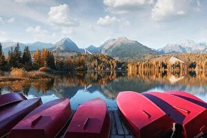 Images Dated 10th October 2018: Picturesque autumn landscape with row of red wooden boats and high mountains on background