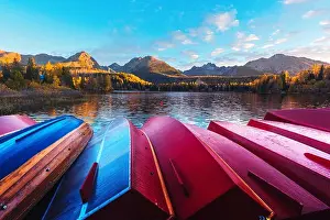Picturesque autumn view of lake Strbske pleso in High Tatras National Park, Slovakia. Row of red wooden boats and high mountains on background