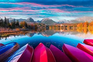 Picturesque autumn view of lake Strbske pleso in High Tatras National Park, Slovakia. Row of red wooden boats and high mountains on background