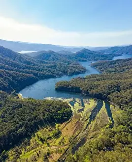 Picturesque drone view of green vegetation washing by river water against sunset sky in countryside in Australia