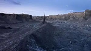 Picturesque drone view of spire shaped rock located in volcanic terrain against scenic sky with moon in Long Dong