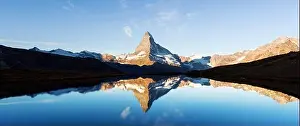 Picturesque landscape with colorful sunrise on Stellisee lake. Snowy Matterhorn Cervino peak with reflection in clear water. Zermatt, Swiss Alps