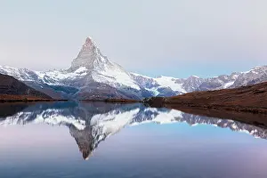 Picturesque landscape with colorful sunrise on Stellisee lake. Snowy Matterhorn Cervino peak with reflection in clear water. Zermatt, Swiss Alps