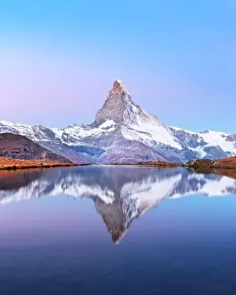 Picturesque landscape with colorful sunrise on Stellisee lake. Snowy Matterhorn Cervino peak with reflection in clear water. Zermatt, Swiss Alps