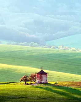 Picturesque rural landscape with old windmill and green sunny spring hills. South Moravia region, Czech Republic