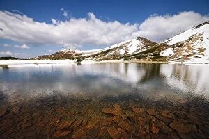 Images Dated 21st May 2016: Picturesque spring landscape with snowy hills and clear mountain lake under a blue sky