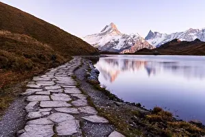 Picturesque view on Bachalpsee lake in Swiss Alps mountains. Snowy peaks of Wetterhorn, Mittelhorn and Rosenhorn on background
