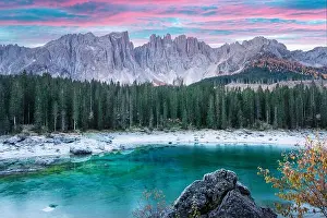 Picturesque view on frozen Karersee lake in Bolzano province - South Tyrol. Pink sunrise in Italian Dolomite Alps. Landscape photography