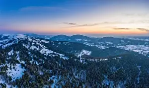 Wintersport Prints: Picturesque winter panorama of mountain hills covered with snow and fir trees on a sunny clear day with the sun