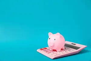 Loan Prints: Piggy bank and calculator on blue background. Space for text