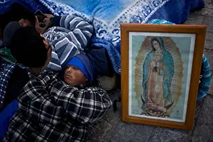 Catholic Faith Prints: A pilgrim sleeps by an image of the Our Lady of Guadalupe virgin in Mexico City