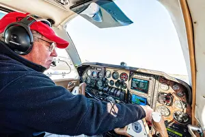 Concentrate Prints: a pilot is doing his pre flight check before taking off in his beechcraft baron