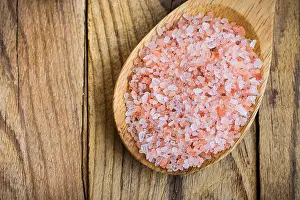 Himalayan Prints: Pink Himalayan salt in wooden spoon on plank wood background