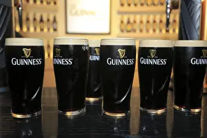 Cnmages Prints: Pints of Guinness Draught beer on top of bar counter of the testing room of Guinness Storehouse