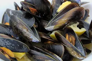 Crustacean Prints: Detail of a plate full of cooked mussels ready to be tasted by diners