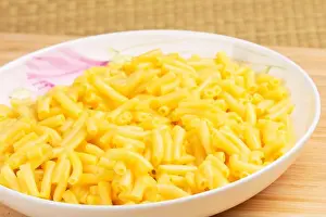 Fork Prints: Plate full of delicious Macaroni and cheese on a wooden background