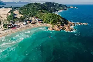 Holiday Beach Prints: Popular holiday beach with cape and Atlantic ocean with waves in Brazil. Aerial view