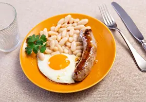 Bean Prints: Portion of breakfast food is fried egg and pork sausage with stewed beans