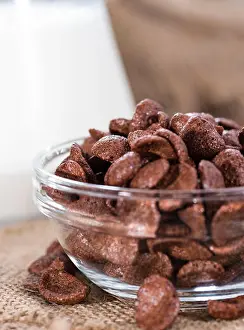 Cacao Prints: Portion of chocolate cornklakes on wooden background (close-up shot)