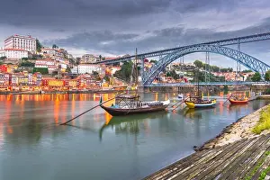 Porto, Portugal old town skyline on the Douro River with rabelo boats at dusk