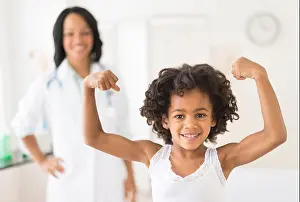 Three Quarter Prints: Portrait of African American girl flexing muscles in doctor's office