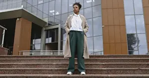 Pensive Prints: Portrait of an African-American student in thought standing on the steps against the backdrop of an administrative city