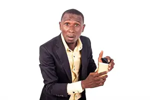 portrait of an astonished young businessman holding a paper coffee cup while looking at the camera