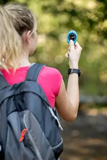 Compass Prints: portrait of an attractive blond girl using a compass outdoors