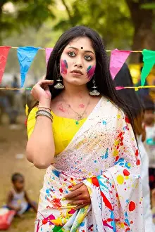 Saree Prints: Portrait of beautiful happy young Indian woman with spring festive make up celebrating Holi with powder colours