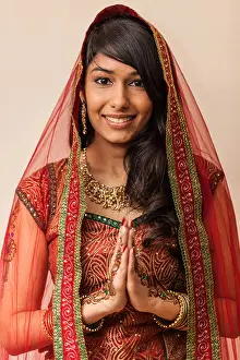 Sari Prints: Portrait of a beautiful Indian woman dressed in traditional clothing holding hands in Namaste gesture