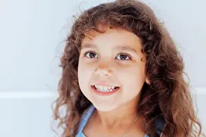 Skirt Prints: Portrait of a beautiful little curly girl in a blue dress
