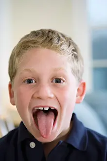 Contentment Prints: Portrait of a boy sticking out tongue