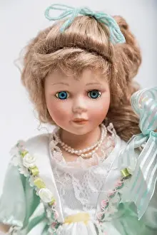 Portrait of a ceramic porcelain handmade vintage doll with long blond hair